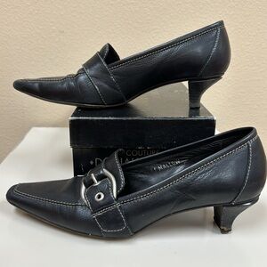 Donald J. Pliner leather shoes with silver hardware.